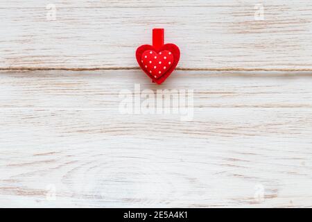 Un coeur rouge à pois sur une épinglette sur un fond rustique en bois. Contexte de la Saint-Valentin. Espace pour le texte Banque D'Images