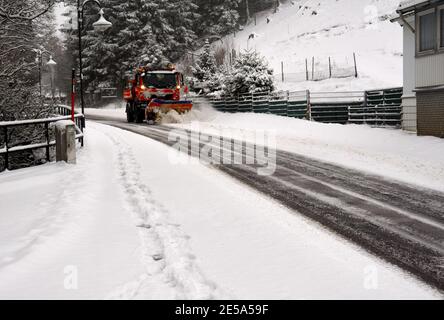 Le véhicule déneigement dégage l'entrée du village de Altenau dans les montagnes Harz de neige Banque D'Images