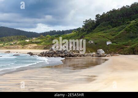 La plage de San Anton, vide par une journée d'été froide et nuageux, à O Porto de Espasante, dans la région d'Ortigueira, dans le nord de la Galice, en Espagne. Banque D'Images