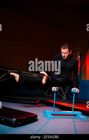 Portrait d'un homme de gymnaste dans les vêtements de sport, homme faisant des exercices sur un cheval dans la salle de gym Banque D'Images