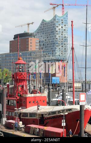 Bateau de lumière dans le port de Hambourg et le Hall Philharmonique d'Elbe en construction Banque D'Images