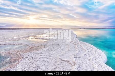 Le soleil du matin brille sur les formations de cristaux de sel, clair vert cyan eau calme près, paysage typique à la plage d'Ein Bokek, Israël Banque D'Images