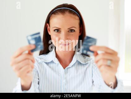 Femme tenant la carte de crédit coupée en deux Banque D'Images