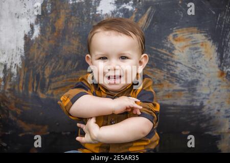 Un bébé garçon de onze mois en plein air en hiver dans un cadre de centre-ville. Banque D'Images