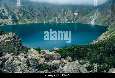 Lac de surface bleu profond dans le paysage de brume de montagne. Montagnes Tatra, Czarny Staw, Pologne Banque D'Images