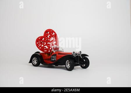 Volgograd, Russie-17 janvier 2021. Une petite voiture rouge rétro bugatti porte un coeur. Le concept de la Saint-Valentin. Banque D'Images