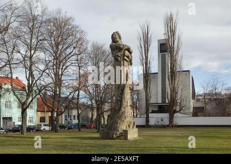 Monument à Jan Hus conçu par le sculpteur symboliste tchèque František Bílek (1914) à Kolín en Bohême centrale, République tchèque. La Congrégation de l'église tchécoslovaque hussite (Husův sbor) conçue par l'architecte tchèque Vladimír Walenfels et achevée en 1932 est vue en arrière-plan. Banque D'Images