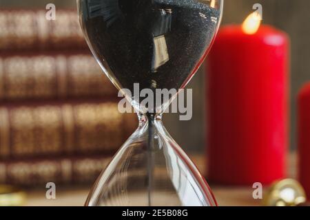 HourGlass et bougies allumées rouges en gros plan Banque D'Images