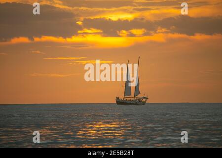 Voile au coucher du soleil sur la plage de Tamarindo au Costa Rica, en Amérique centrale... Banque D'Images