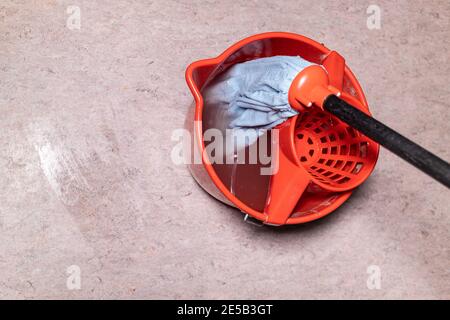 vue de dessus de la vadrouille dans un seau rouge avec de l'eau sale à la maison Banque D'Images