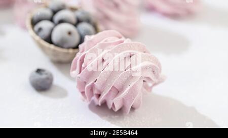 Guimauve artisanale aux myrtilles, fond blanc. Violet Marshmallow, meringue, Zephyr foyer sélectif Banque D'Images