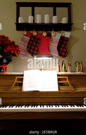 Décorations de Noël sur piano avec musique et bas suspendus Banque D'Images