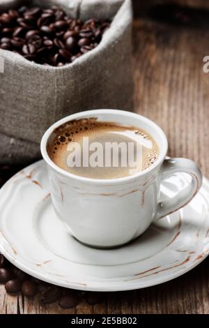 Tasse de café et sac de jute sur table en bois. Fête Banque D'Images