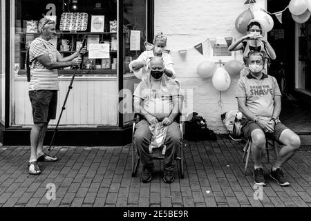 Des hommes qui ont rasé leurs cheveux pour recueillir de l'argent pour la Macmillan cancer Care Charity, High Street, Lewes, East Sussex, Royaume-Uni. Banque D'Images