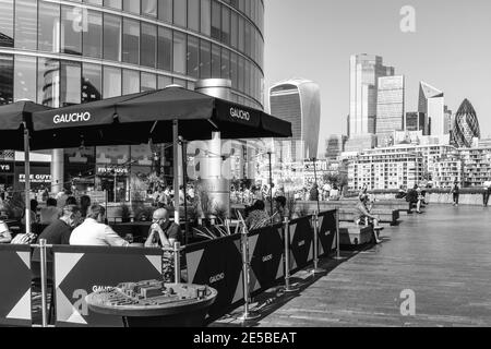 Les gens qui font leurs repas à l'extérieur au restaurant Gaucho (Tower Bridge) avec la City of London dans le Backround, London Bridge City Area, Londres, Royaume-Uni. Banque D'Images