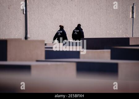 Berlin, Berlin, Allemagne. 27 janvier 2021. La police peut être vue derrière des dalles de béton du Mémorial aux Juifs assassinés d'Europe (en allemand : Denkmal für die ermordeten Juden Europas), également connu sous le nom de Mémorial de l'Holocauste (en allemand : Holocauste-Mahnmal) lors de la Journée internationale du souvenir de l'Holocauste. Le 27 janvier 2021 marque la Journée internationale de commémoration en mémoire des victimes de l'Holocauste, 76 ans après la libération du camp de concentration nazi d'Auschwitz. Crédit : Jan Scheunert/ZUMA Wire/Alay Live News Banque D'Images