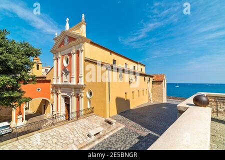 Vue sur la cathédrale d'Antibes sur la petite place de la ville sous un beau ciel comme mer Méditerranée en arrière-plan à Antibes, France. Banque D'Images