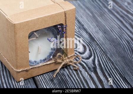 Bougie décorative dans un emballage artisanal. Noué avec un cordon et décoré de branches de lavande. Banque D'Images