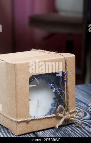 Bougie décorative dans un emballage artisanal. Noué avec un cordon et décoré de branches de lavande. Banque D'Images