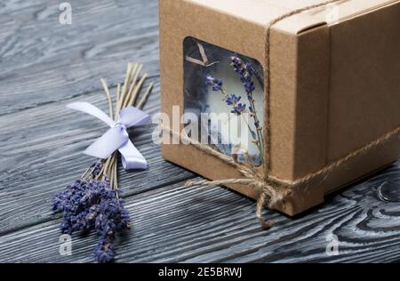 Bougie décorative dans un emballage artisanal. Noué avec un cordon et décoré de branches de lavande. Banque D'Images