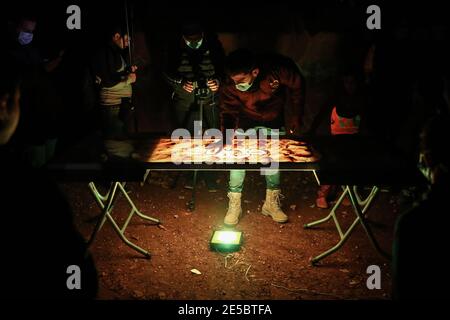 Killi, Syrie. 27 janvier 2021. Un homme travaille sur une œuvre d'art réalisée par la boue lors d'une exposition organisée par l'équipe de bénévoles Violet dans un camp du village de Killi où tous les portraits sont peints de la boue pour attirer l'attention du monde entier sur les conditions des personnes déplacées tout au long de la saison d'hiver. Credit: Aras Alkharboutli/dpa/Alamy Live News Banque D'Images