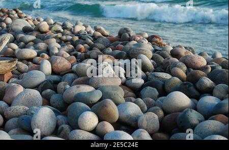 Plage rocheuse multicolore avec vagues en arrière-plan Banque D'Images