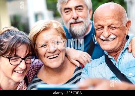 Des amis aînés heureux emportant un selfie dans la vieille ville - Les retraités s'amusent avec leur téléphone mobile - positif concept de mode de vie des personnes âgées Banque D'Images