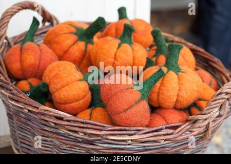 Petits citrouilles artificielles en feutre dans un panier Banque D'Images