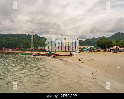 Kaimana, Arguni Bay, Indonésie - février 2018 : bateaux en bois colorés et synagogue dans le port d'une petite ville sur la péninsule de Bird's Head, West Papu Banque D'Images