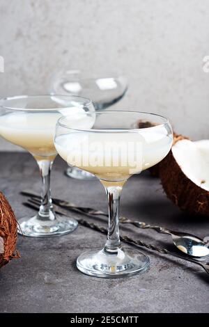 Liqueur Pina Colada dans un verre et des moitiés de noix de coco. Banque D'Images