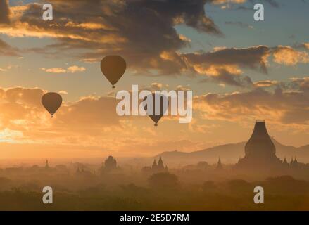 Silhouette de ballons à air chaud volant au-dessus des temples au coucher du soleil, Bayan, Myanmar Banque D'Images