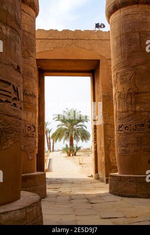 Vue à travers les majestueuses colonnes du temple de Karnak à travers une porte, Louxor Banque D'Images