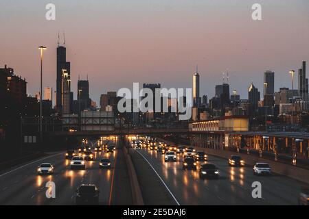 Horizon de la ville et voitures longeant l'autoroute au coucher du soleil, Chicago, Illinois, États-Unis Banque D'Images