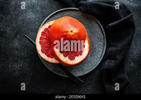 Tranches de pamplemousse rose sur une assiette en pierre Banque D'Images