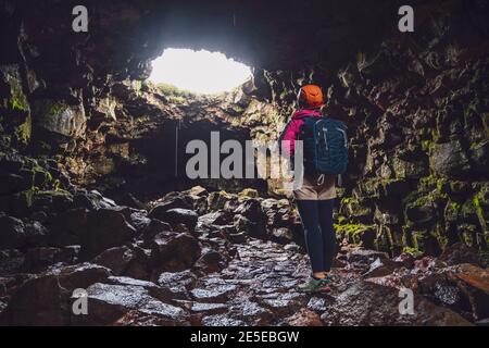 Une femme voyageur explore le tunnel de lave en Islande. Raufarholshellir est un beau monde caché de caverne. C'est l'une des plus longues et des plus connues lave