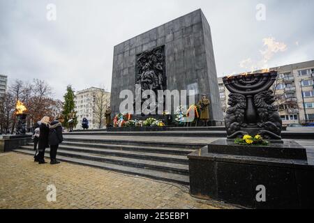 Varsovie, Pologne. 27 janvier 2021. Le 27 janvier 2021, les gens font leurs respects aux victimes de l'Holocauste au monument des héros du ghetto à Varsovie, en Pologne. Dans le cadre de la pandémie COVID-19 en cours, la Pologne a commémoré mercredi la Journée internationale de la mémoire de l'Holocauste, presque entièrement en ligne, avec des événements en direct limités, notamment des gardes d'honneur et la pose de couronnes à divers monuments dans tout le pays. Credit: Jaap Arriens/Xinhua/Alamy Live News Banque D'Images