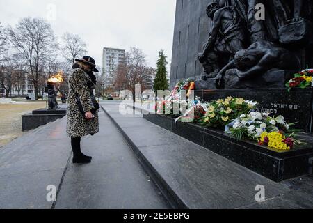 Varsovie, Pologne. 27 janvier 2021. Une femme rend hommage aux victimes de l'Holocauste au monument des héros du ghetto à Varsovie, en Pologne, le 27 janvier 2021. Dans le cadre de la pandémie COVID-19 en cours, la Pologne a commémoré mercredi la Journée internationale de la mémoire de l'Holocauste, presque entièrement en ligne, avec des événements en direct limités, notamment des gardes d'honneur et la pose de couronnes à divers monuments dans tout le pays. Credit: Jaap Arriens/Xinhua/Alamy Live News Banque D'Images