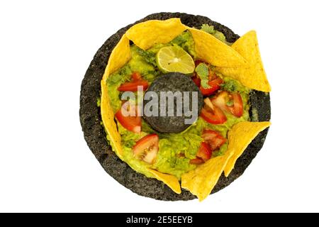 Vue de dessus trempez l'avocat avec du citron, de l'ail, de la coriandre, de la tomate garnie de frites dans un bol en pierre Banque D'Images