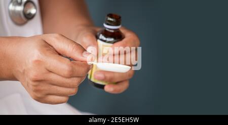 healthcare, treatment and medicine concept - bottle of medication or antipyretic syrup and spoon Stock Photo