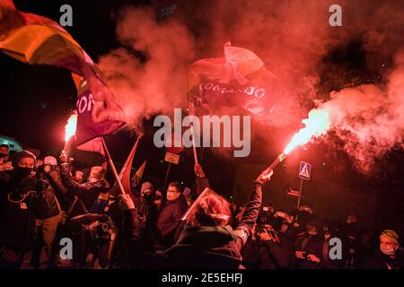 Varsovie, Pologne. 27 janvier 2021. Des manifestants tiennent des fusées éclairantes et des drapeaux en feu pendant la manifestation.des centaines ont envahi les rues de Varsovie pour participer à une manifestation organisée par la grève des femmes (Strajk Kobiet) contre le parti droit et Justice (PiS) au pouvoir et contre la décision de la Cour constitutionnelle. Un verdict de la Cour constitutionnelle polonaise limitant l'accès à l'avortement est entré en vigueur le 27 janvier, a déclaré le gouvernement polonais, trois mois après avoir déclenché des manifestations dans tout le pays. Crédit : SOPA Images Limited/Alamy Live News Banque D'Images