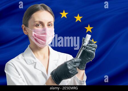 La jeune fille prépare la vaccination sur fond de drapeau de l'Union européenne. Concept de vaccination Banque D'Images