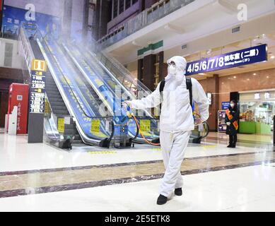 Pékin, Chine. 27 janvier 2021. Un membre du personnel vaporise du désinfectant à la gare de Beijing, à Beijing, capitale de la Chine, le 27 janvier 2021. La course de voyage du Festival de printemps, connue comme la plus grande migration humaine annuelle au monde, dure 40 jours du 28 janvier au 8 mars de cette année. Credit: Zhang Chenlin/Xinhua/Alay Live News Banque D'Images