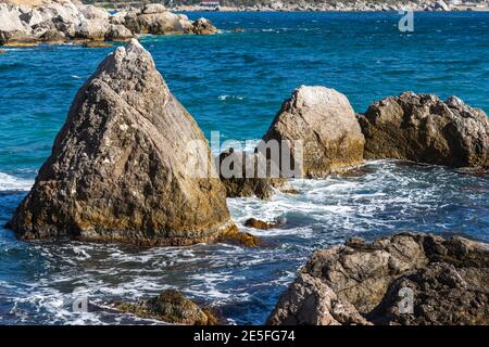 Plage turquoise en pierre de mer, vagues déferlantes en plein soleil. Fond marin coloré et lumineux. Le concept de l'été, des vacances, des voyages. Le clea le plus pur Banque D'Images