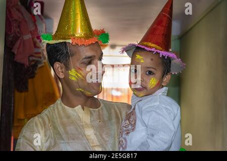 père et fille appréciant la fête des holi le festival des couleurs gros plan est l'expression de l'enfant tout en appréciant les holi indiens Banque D'Images