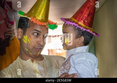 père et fille appréciant la fête des holi le festival des couleurs gros plan est l'expression de l'enfant tout en appréciant les holi indiens Banque D'Images