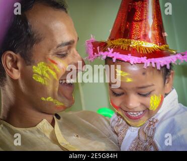 père et fille appréciant la fête des holi le festival des couleurs gros plan est l'expression de l'enfant tout en appréciant les holi indiens Banque D'Images