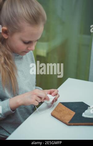 la petite fille est engagée dans le travail des aiguilles à la maison Banque D'Images