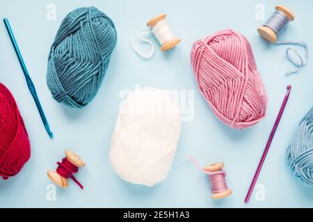 Crochets en crochet multicolores avec boules de fil sur un bleu arrière-plan Banque D'Images