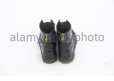 Une paire de bottes noires emblématiques Dr Marten dans la neige en hiver. Banque D'Images