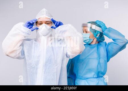 Médecin et infirmière pendant le quart de travail dans l'équipement de protection médicale. Le concept de lutte contre la pandémie et le covid 19. Arrière-plan blanc. Banque D'Images